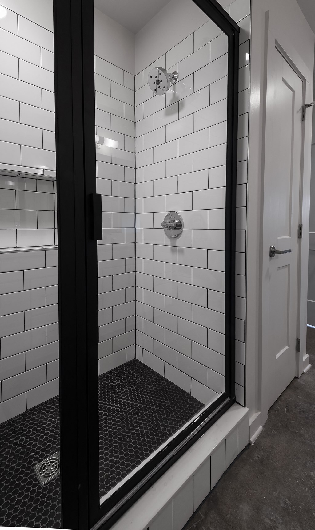 a black and white photo of a shower in a bathroom
